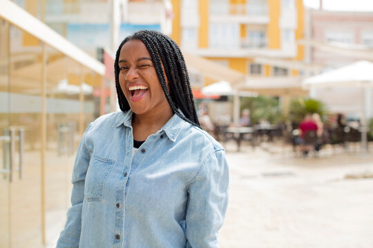 afro pretty black woman with a big, friendly, carefree smile, looking positive, relaxed and happy, chilling