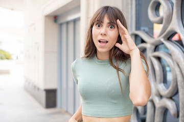 pretty young woman looking happy, astonished and surprised, smiling and realizing amazing and...