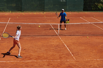 A professional tennis player and her coach training on a sunny day at the tennis court. Training and preparation of a professional tennis player