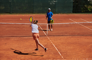 A professional tennis player and her coach training on a sunny day at the tennis court. Training and preparation of a professional tennis player