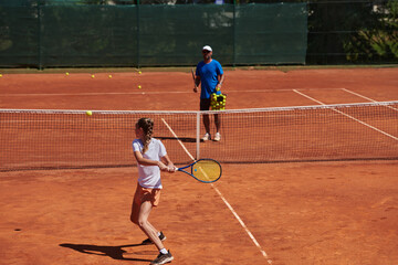 A professional tennis player and her coach training on a sunny day at the tennis court. Training and preparation of a professional tennis player