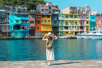 woman traveler visiting in Taiwan, Tourist with backpack and hat sightseeing in Keelung, Colorful Zhengbin Fishing Port, landmark and popular attractions near Taipei city . Asia Travel concept - obrazy, fototapety, plakaty