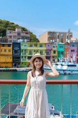 Obraz na płótnie Canvas woman traveler visiting in Taiwan, Tourist with hat sightseeing in Keelung, Colorful Zhengbin Fishing Port, landmark and popular attractions near Taipei city . Asia Travel concept