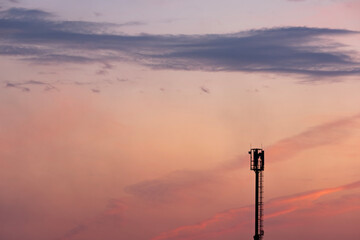 Silhouettes telecommunication tower at sunset. Beautiful sky