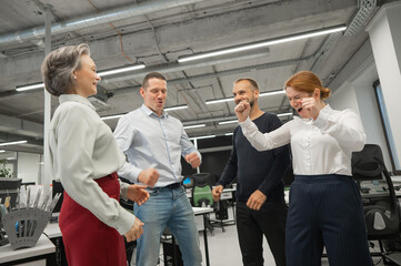 Fototapeta na wymiar Four colleagues rejoice in success in the office.