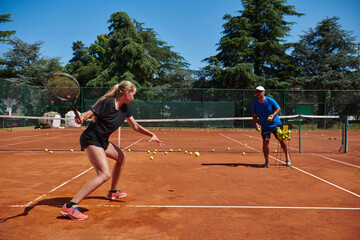 Obraz premium A professional tennis player and her coach training on a sunny day at the tennis court. Training and preparation of a professional tennis player