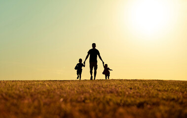 Father running with his children through an infinite and wonderful field on Father's Day - obrazy, fototapety, plakaty