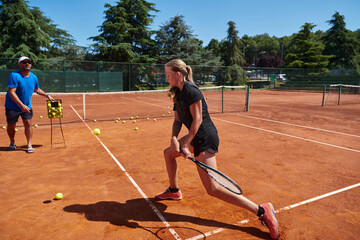 A professional tennis player and her coach training on a sunny day at the tennis court. Training and preparation of a professional tennis player