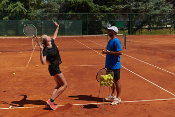 A professional tennis player and her coach training on a sunny day at the tennis court. Training...