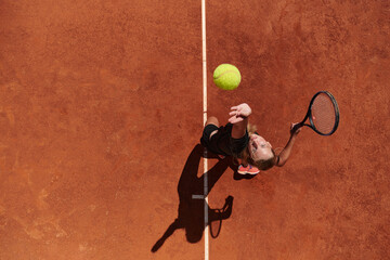 Top view of a professional tennis player serves the tennis ball on the court with precision and...
