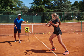 Obraz premium A professional tennis player and her coach training on a sunny day at the tennis court. Training and preparation of a professional tennis player