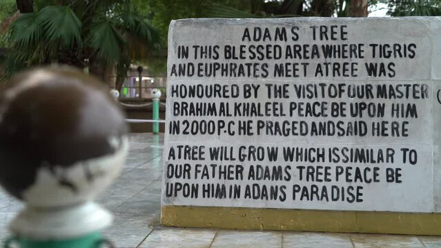 Marble stone near Tree of Adam or of Knowledge with inscription in English, El Qurna in Iraq. Static view and focus in background
