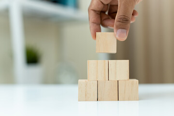 concept of grow success. hand holding and stacking wooden block cube step of business growth...