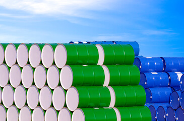 Piles of many colorful oil drums stacked in industrial yard area against blue sky background
