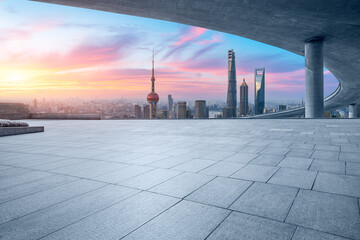 Empty square floor and bridge with city skyline at sunset in Shanghai