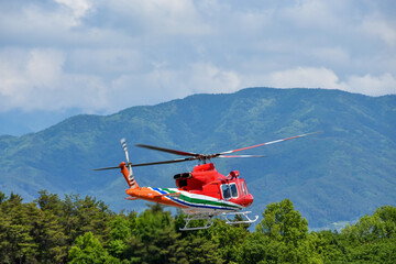 大自然の中を飛ぶ防災ヘリコプター