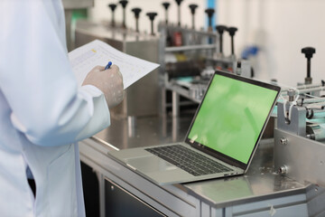 Inspector man or worker male hands doing quality of mask and medical face mask production line with blank green screen computer, Industry and factory concept.