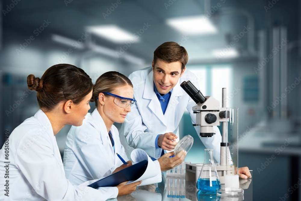 Wall mural Young researcher with samples and microscope in lab