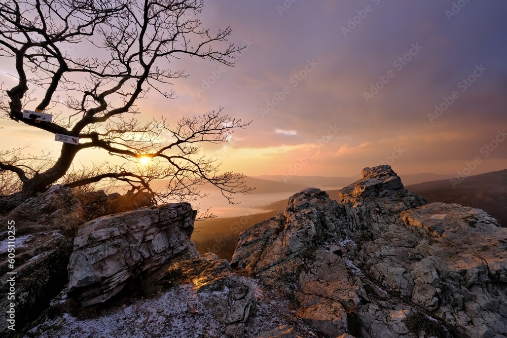 Wall mural Tourist view on the rock at a beautiful, colorful sunset. Mountain and adventure tourism with a healthy lifestyle.