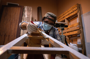 Craftsman, Carpenter using a paintbrush painting to wooden bar chair handmade at woodworking workshop or carpentry workplace.
