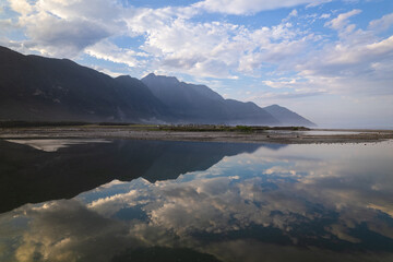 A still body of water in Taiwan reflecting beautiful mountains and blue sky