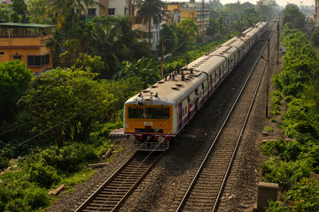 9th April, 2023, Kolkata, West Bengal, India: A local electric train on railway track of local train of Sealdah south main line in a bright day light with blue sky.