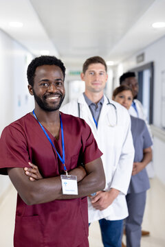 Unaltered portrait of smiling african american male doctor and diverse colleagues in hospital