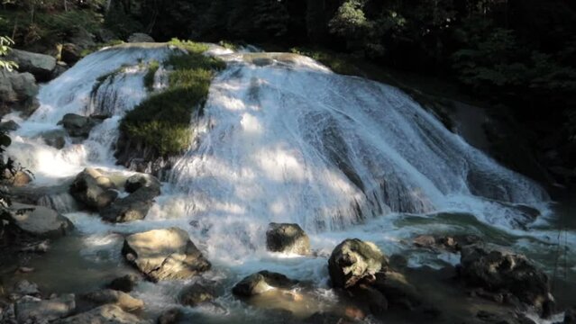 hermosa cascada blanca con mucha agua fluyendo y vegetaci&oacute;n verde alrededor.