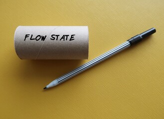 On yellow background, empty toilet roll with text written FLOW STATE,positive mental state which...