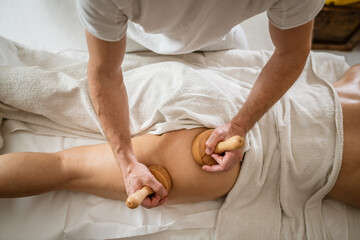 Fototapeta na wymiar Caucasian woman having madero therapy massage anti-cellulite treatment
