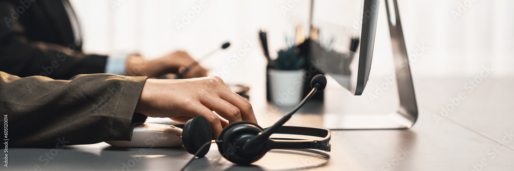 Aufkleber panorama focus hand holding headset on call center workspace desk with blur background of operator t
