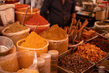 Assorted colorful, mixed spices selling at Goa trading. Salesman sell different grounded flavorings on commerce.