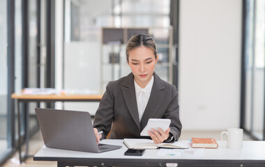 Young Asian businesswoman working on documents at office