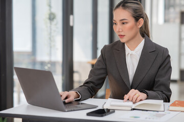 Young Asian businesswoman working on documents at office