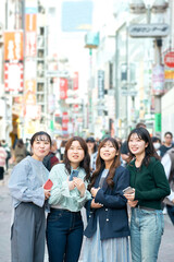 街中でスマホを使う若い女性達