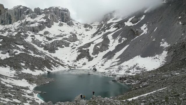 team of mountaineers exploring the glacial lake at the top of the mountains