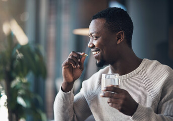 Black man, pill or medicine and a glass of water in a house for health and wellness with a smile....