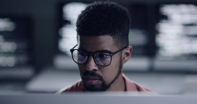 Face, glasses and code with a man programmer working in a dark office for data processing. Focus, software development and programming with a male coder reading computer language on a database