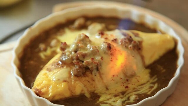 The curry has an egg on top and is cooked over a fire.