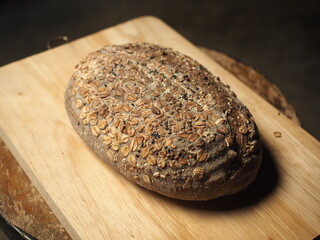 multigrain whole wheat bread loaf on wooden board
