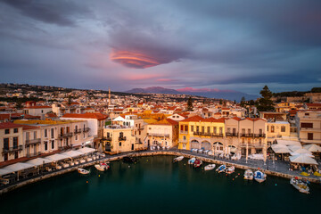 Fototapeta na wymiar Greece's enchanting Rethymno: A mesmerizing sunrise over the old harbor and town of Rethymno in Crete, casting a golden glow on ancient Greek beauty