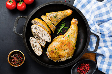 Baked Stuffed Chicken Legs in a Pan on Dark Backround