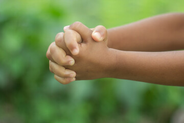 The two hands are in fists and the background is a green blur