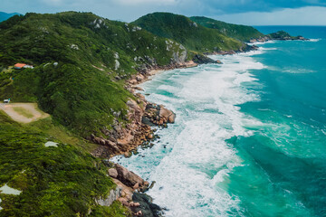 Coastline with stormy ocean and scenic cloudy sky. Aerial view with mountains and ocean with waves
