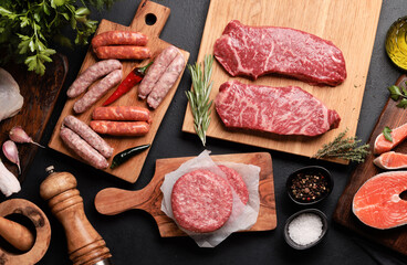 Various raw meat and fish. Steaks, sausages, salmon, chicken and spices