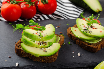 Avocado Toasts with Tomato, Healthy Snack or Breakfast on Dark Background