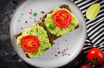 Avocado Toasts with Tomato, Healthy Snack or Breakfast on Dark Background