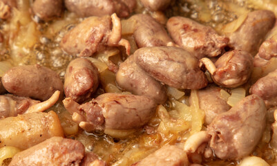 Chicken hearts are fried in a pan in oil