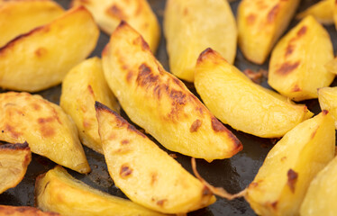 Potatoes baked in the oven as a background.