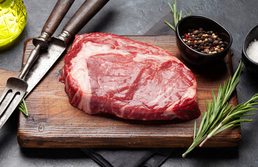 Raw ribeye steak on cutting board